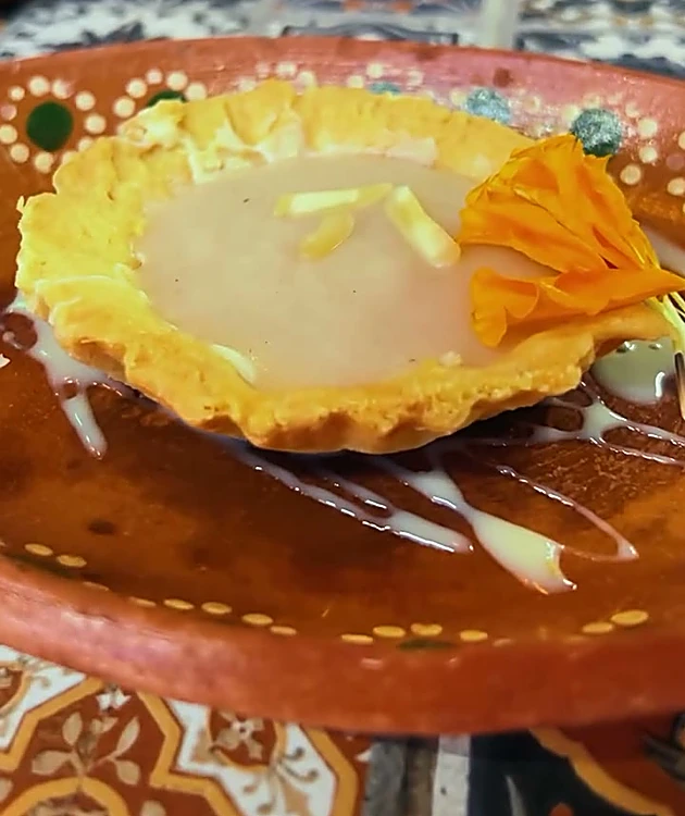 Pay de guanábana con flor de cempasúchil sobre plato de barro