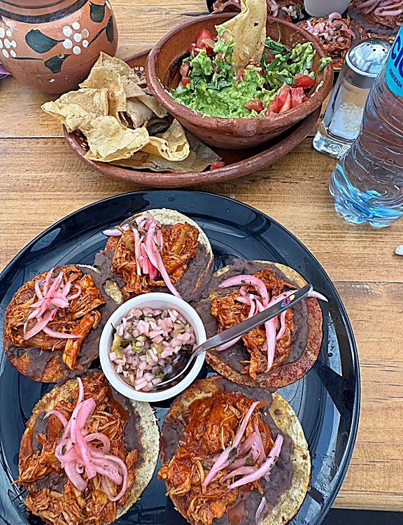 Mesa con tostadas, guacamole fresco y totopos